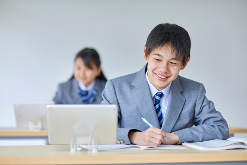タブレットとノートで学ぶ中学生